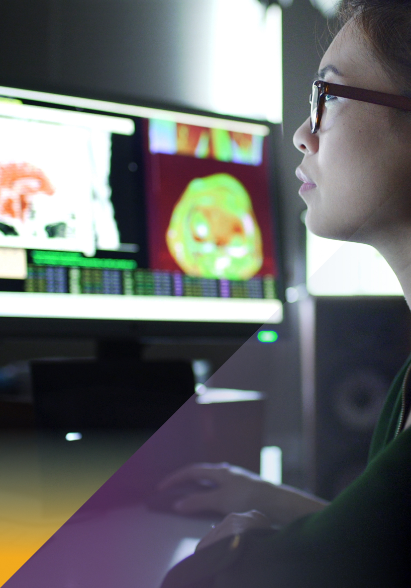 Woman looking at medical imaging data on multiple screens / Femme regardant des données d'imagerie médicale sur plusieurs écrans