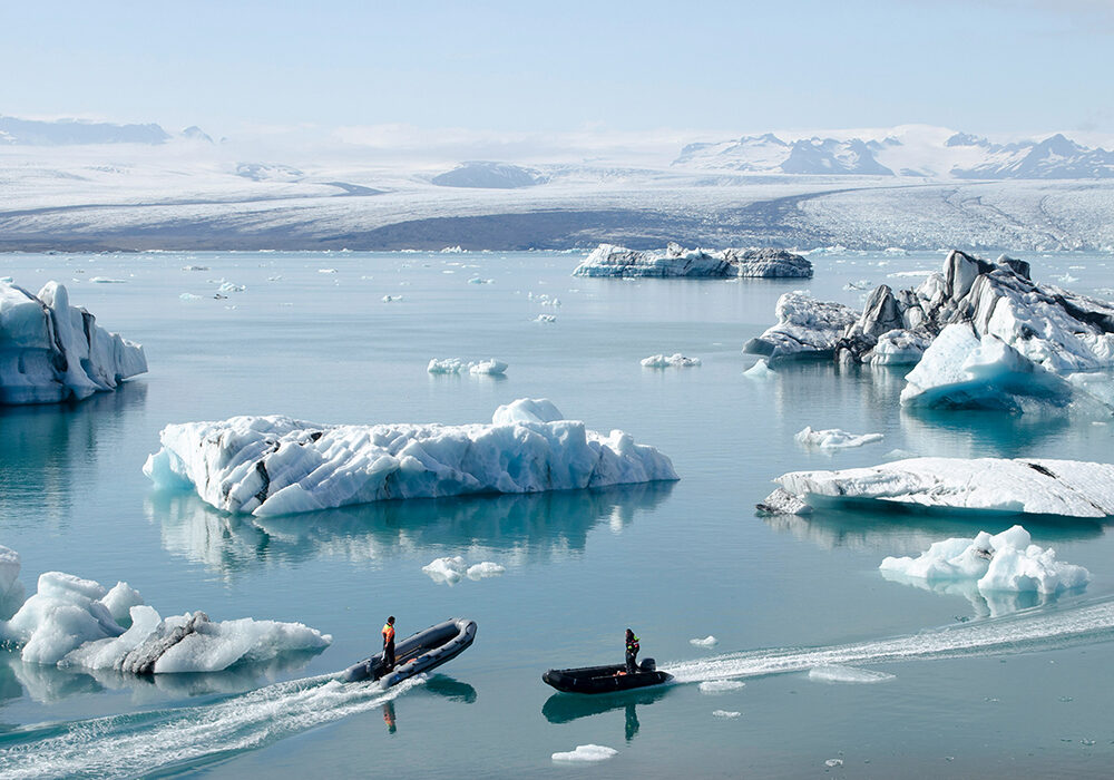 Melting ice at the Arctic. Two men in two boats