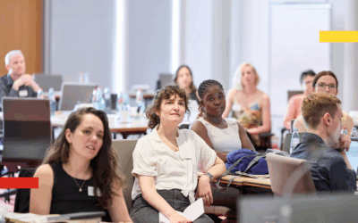 People sitting at tables and listening to speaker